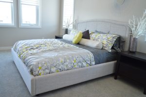 bedroom with grey bedspread and yellow flowers